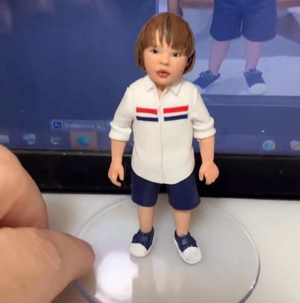 Miniatura de menino com camisa branca listrada e bermuda azul
